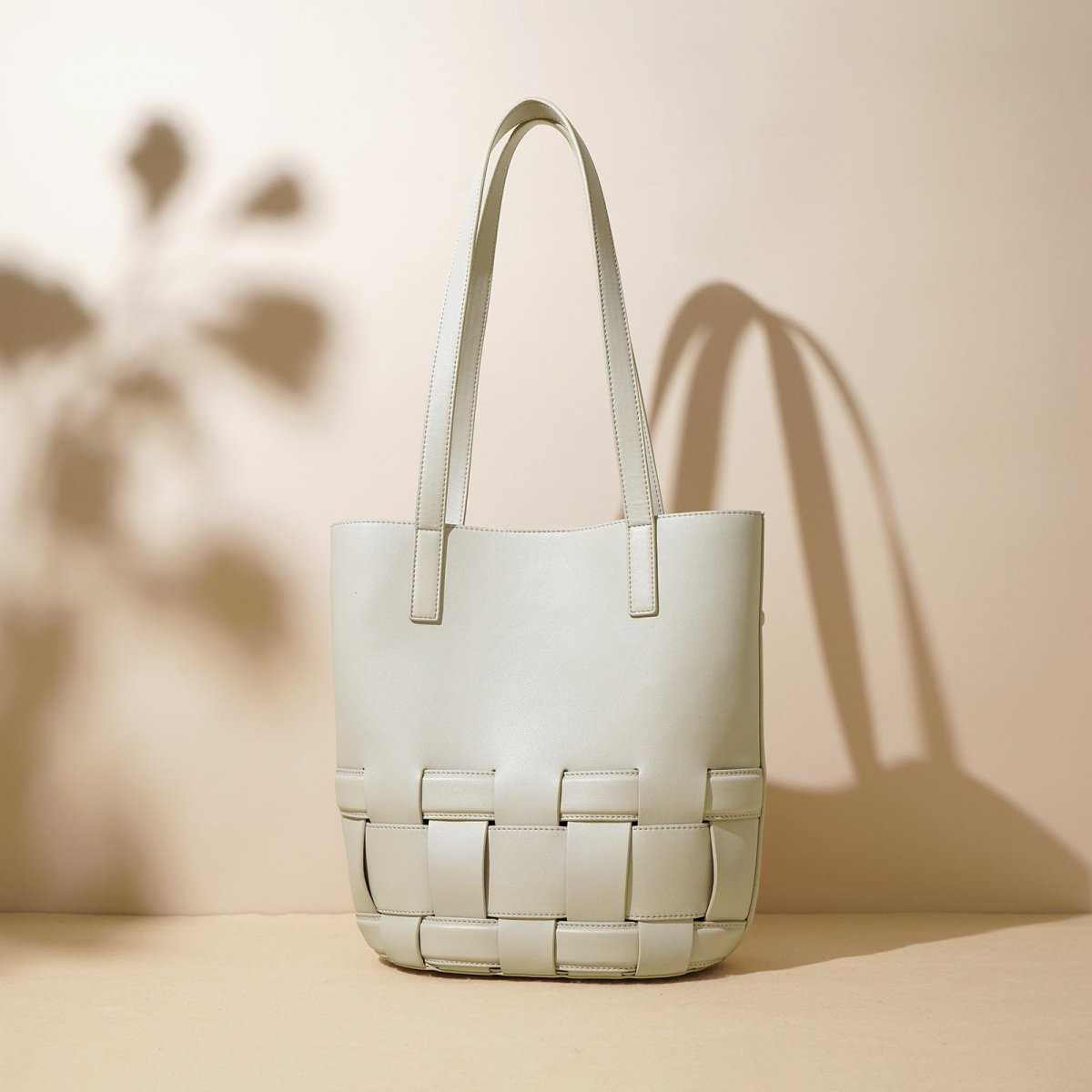 Woven cowhide leather tote bag with structured handles and classic silhouette on display