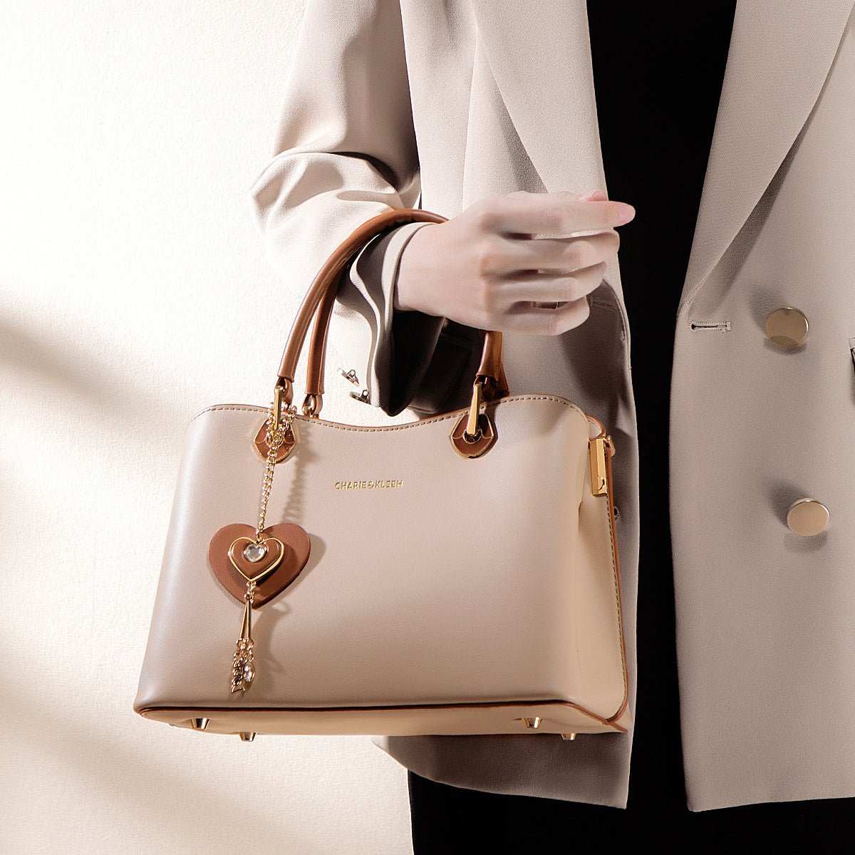 Convertible high-end handbag, apricot with brown accents, worn as crossbody, organized compartments visible
