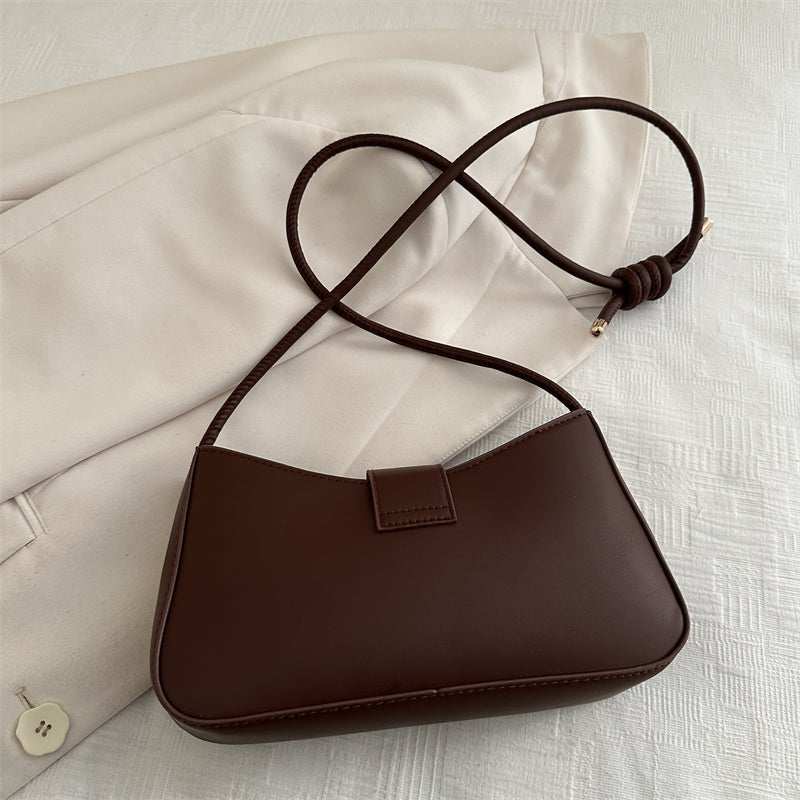 Elegant black handbag for women with gold zipper hardware and adjustable crossbody strap, on white background