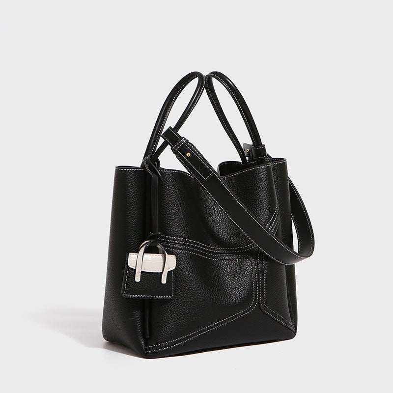 Side angle of Urban Chic genuine leather tote bag, showing structured profile and smooth finish