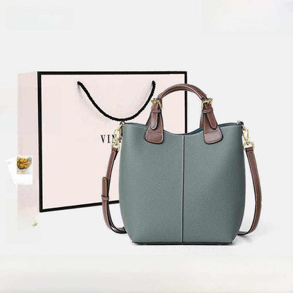 Crossbody bags for women in muted green genuine leather with brown handles and adjustable strap, featuring a minimalist bucket silhouette