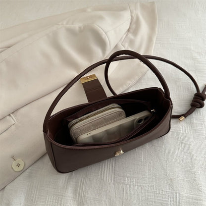 Women’s everyday structured handbag displayed with essentials—phone, wallet, keys—to show storage capacity