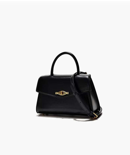 Crossbody handbag in black synthetic leather with a structured shape, top handle, shoulder strap, and gold vintage buckle