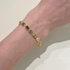 Vintage gold bracelet with green zircon gemstones displayed on wrist, highlighting elegant design and superior craftsmanship.